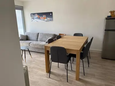 a living room with a wooden table and chairs at Appart 6 personnes, balcon plein sud in Flaine