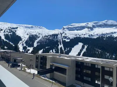 a building with a snow covered mountain in the background at Appart 6 personnes, balcon plein sud in Flaine