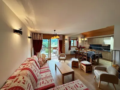 a living room with a couch and a kitchen at Spacieux duplex dans une résidence avec piscine - FR-1-624-137 in Samoëns