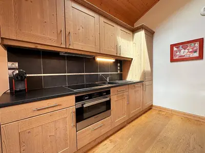 a kitchen with wooden cabinets and a sink at Spacieux duplex dans une résidence avec piscine - FR-1-624-137 in Samoëns