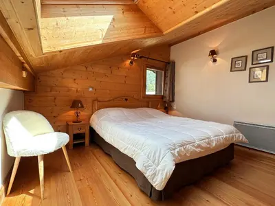 a bedroom with a bed and a chair in a room at Spacieux duplex dans une résidence avec piscine - FR-1-624-137 in Samoëns