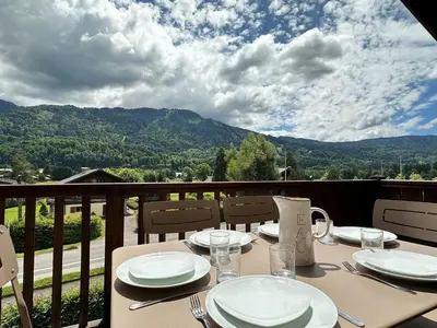 a table on a balcony with a view of a mountain at Spacieux duplex dans une résidence avec piscine - FR-1-624-137 in Samoëns