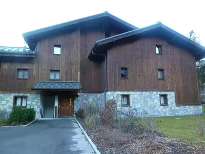 a large wooden building with a door and a driveway at Spacieux duplex dans une résidence avec piscine - FR-1-624-137 in Samoëns