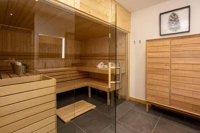 a sauna with wooden cabinets and a glass wall at Chalet Bonnabelle - Chamonix All Year in Chamonix-Mont-Blanc