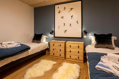a room with two beds and a painting on the wall at Chalet Bonnabelle - Chamonix All Year in Chamonix-Mont-Blanc