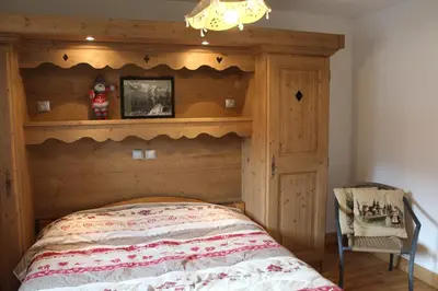 a bed with a wooden headboard in a bedroom at Chardons Argentés in Samoëns