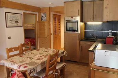 a kitchen with a table and a kitchen with a stove and refrigerator at Chardons Argentés in Samoëns