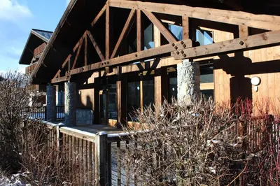 a wooden house with a fence in front of it at Chardons Argentés in Samoëns