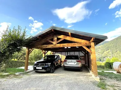 two cars parked in a garage with a wooden structure at Chalet familial Saint-Gervais in Saint-Gervais-les-Bains