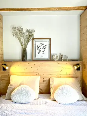 a bedroom with a wooden headboard with two pillows on a bed at Chalet familial Saint-Gervais in Saint-Gervais-les-Bains