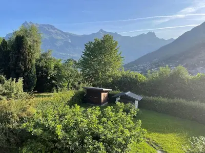 a bench in a field with mountains in the background at Chalet familial Saint-Gervais in Saint-Gervais-les-Bains