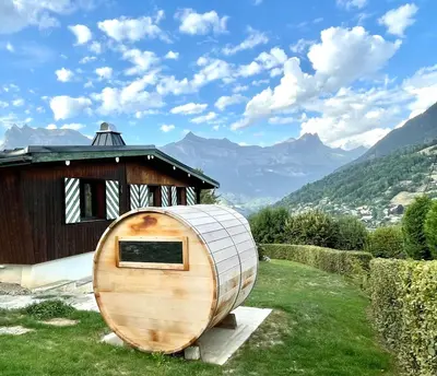 a large wooden hobbit house next to a building at Chalet familial Saint-Gervais in Saint-Gervais-les-Bains