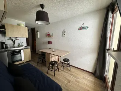 a small room with a table and a kitchen at Samoens 1600, Grand Massif in Samoëns