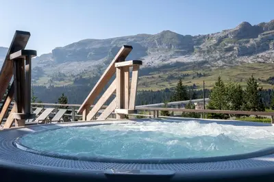 a table with a bowl of fruit on a balcony with mountains at Résidence Pierre & Vacances Premium Les Terrasses d'Hélios in Flaine