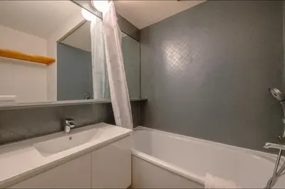 a bathroom with a tub and a sink and a mirror at Chamonix Sud - Bâtiment Iris 374 - Happy Rentals in Chamonix-Mont-Blanc
