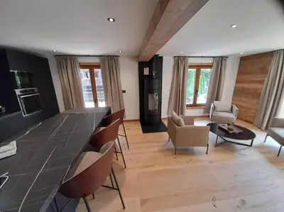 a living room with a long table and chairs at Chalet Henriette by Brennus Chamonix in Chamonix-Mont-Blanc