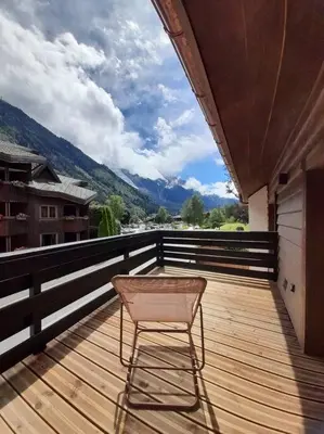 a chair sitting on top of a wooden deck at Chalet Henriette by Brennus Chamonix in Chamonix-Mont-Blanc