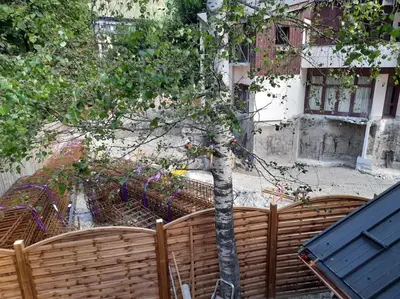 a tree behind a wooden fence with a tree at Chalet Henriette by Brennus Chamonix in Chamonix-Mont-Blanc