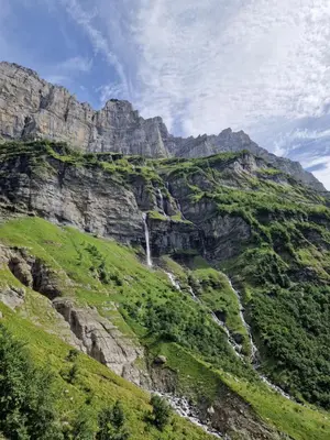 a waterfall on the side of a mountain at Appartement Le Carlina 22B -MERCI DE LIRE TOUT ET disposition des chambres pour éviter une mauvaise note - Ce nest PAS un Hôtel - MINIMUM 5 nuits - sans le linge de maison - Vue sur le Criou - Sil y a de la place sur le parking, vous pouvez vous y garer in Samoëns