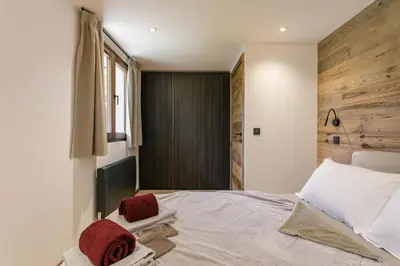 a bedroom with a bed with red towels on it at Chalet Marguerite by Brennus Chamonix in Chamonix-Mont-Blanc