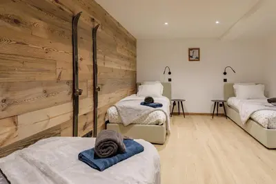 a room with three beds with towels on them at Chalet Claudia by Brennus Chamonix in Chamonix-Mont-Blanc