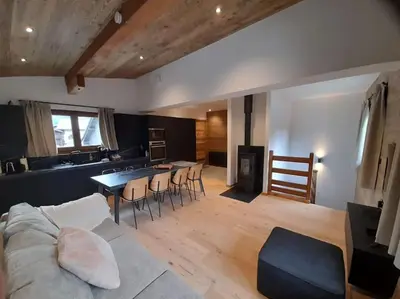 a living room with a couch and a table with chairs at Chalet Claudia by Brennus Chamonix in Chamonix-Mont-Blanc
