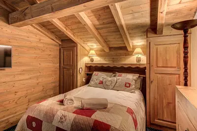 a bedroom with a bed in a log cabin at Chalet Blackbushe – Traditional Chalet - Alpes Travel – Sleeps 4-6 in Les Houches