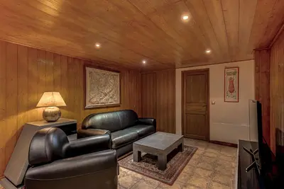 a living room with a leather couch and a table at Chalet Blackbushe – Traditional Chalet - Alpes Travel – Sleeps 4-6 in Les Houches