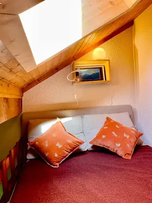 a small room with a couch and two pillows at Appartement 6 personnes les Contamines Montjoie in Les Contamines-Montjoie