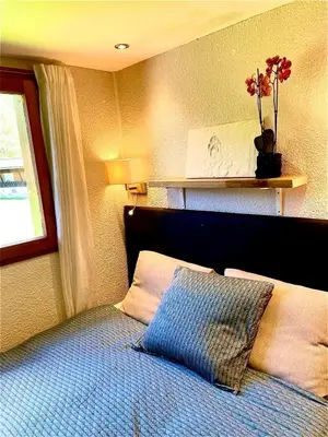 a bedroom with a bed with a pillow and a window at Appartement 6 personnes les Contamines Montjoie in Les Contamines-Montjoie