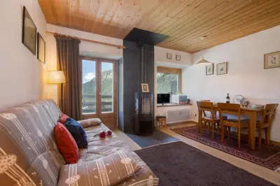 a living room with a fireplace and a kitchen at Résidence Igloo 3 ski in-ski out - Happy Rentals in Le Tour