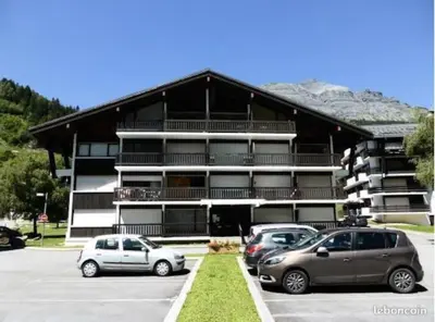 two cars parked in a parking lot in front of a building at Montagne aux Contamines Montjoie Appartement 6-7 personnes in Les Contamines-Montjoie