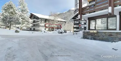 a snow covered street in front of a building at Montagne aux Contamines Montjoie Appartement 6-7 personnes in Les Contamines-Montjoie
