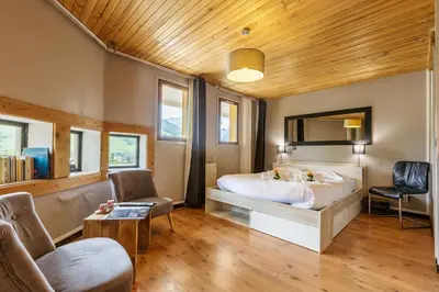a bedroom with a large bed and a wooden ceiling at Appartement Rochebrune De Megève 32 - Happy Rentals in Megève