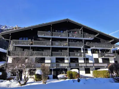 a large white building with balconies and a mountain at Apartment Champraz-17 by Interhome in Chamonix-Mont-Blanc