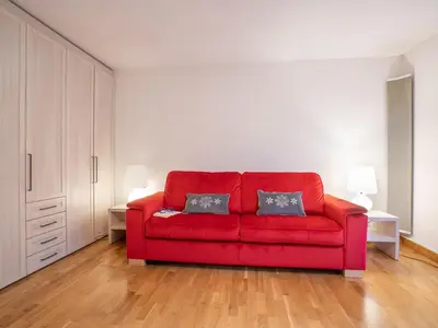 a red couch in a living room with two pillows at Apartment Champraz-17 by Interhome in Chamonix-Mont-Blanc