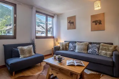a living room with a couch and a table at Gentianes - City center studio next to Aiguille du Midi lift - By Cozee Rentals in Chamonix-Mont-Blanc