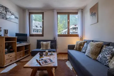 a living room with a blue couch and a coffee table at Gentianes - City center studio next to Aiguille du Midi lift - By Cozee Rentals in Chamonix-Mont-Blanc