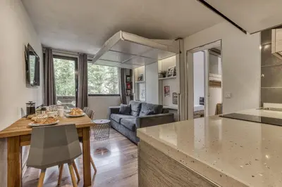 a kitchen and living room with a table and a couch at Aiguille du Grépon - Bright Apartment in the Heart of Chamonix in Chamonix-Mont-Blanc