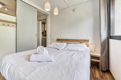 a bedroom with a white bed and a mirror at Aiguille du Grépon - Bright Apartment in the Heart of Chamonix in Chamonix-Mont-Blanc