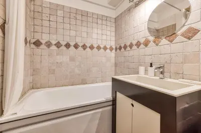 a bathroom with a sink and a tub and a mirror at Aiguille du Grépon - Bright Apartment in the Heart of Chamonix in Chamonix-Mont-Blanc