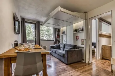 a living room with a table and a couch at Aiguille du Grépon - Bright Apartment in the Heart of Chamonix in Chamonix-Mont-Blanc