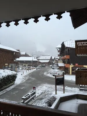 a view from a window of a street covered in snow at Lucada Les Carroz in Les Carroz d'Araches