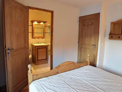 a bedroom with a bed and a bathroom with a sink at Lucada Les Carroz in Les Carroz d'Araches