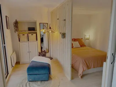 a bedroom with a bed and a blue ottoman at Les Airelles 406 in Les Carroz d'Araches
