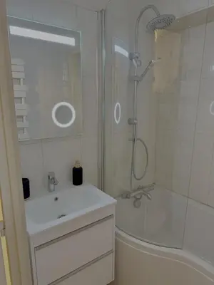 a white bathroom with a shower and a sink at Les Airelles 406 in Les Carroz d'Araches
