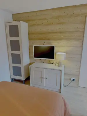 a bedroom with a bed and a tv on a wall at Les Airelles 406 in Les Carroz d'Araches