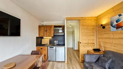 a kitchen and a living room with a couch and a table at Résidence Iris - Studio entièrement rénové avec cabine · Centre station · Balcon MAE-4504 in Magland