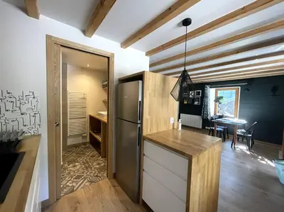 a kitchen with a refrigerator and a dining room at Cosy appartement centre chamonix in Chamonix-Mont-Blanc