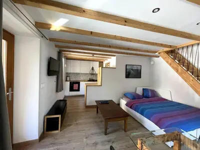 a bedroom with a bed and a table and a staircase at Cosy appartement centre chamonix in Chamonix-Mont-Blanc